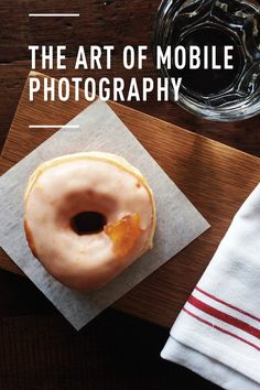 a glazed doughnut sitting on top of a napkin next to a glass of wine
