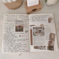 an open book sitting on top of a table next to a clock and other items