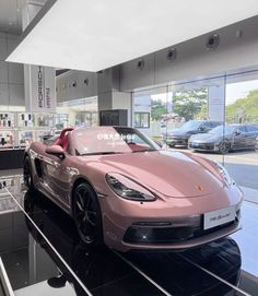 a pink sports car is on display in a showroom