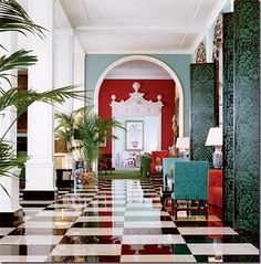 a room with checkered flooring and green plants in the corner on either side