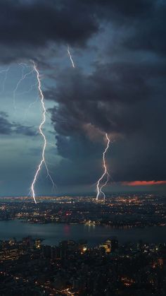 lightning strikes over the city at night time