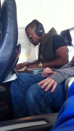 a man sitting in an airplane with headphones on