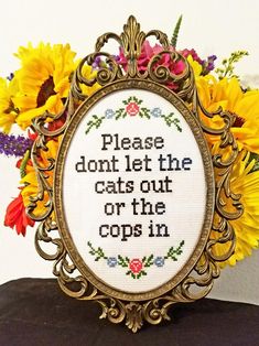 a cross stitch picture frame with sunflowers in the background and a quote on it