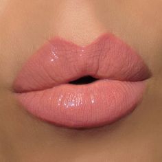 a close up shot of a woman's lips with pink liquid on the lip