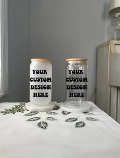 two mason jars sitting on top of a bed with the words your custom design here