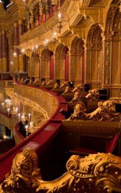 an ornately decorated auditorium with red seats and chandeliers