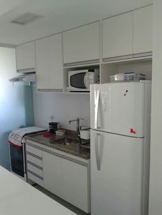 a white refrigerator freezer sitting inside of a kitchen next to a counter top oven
