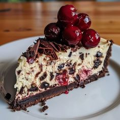 a piece of cheesecake with cherries on top sits on a plate, ready to be eaten