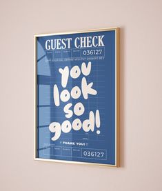 a blue poster with the words guest check hanging on a wall next to a window