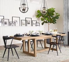 a dining room table with chairs and pictures on the wall in the backround
