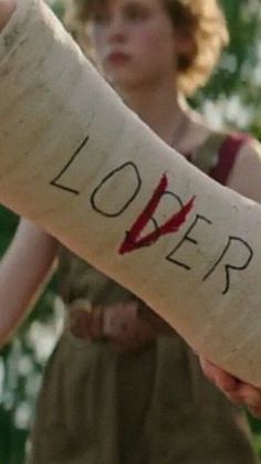 a person holding a piece of cloth with the word lover written on it in red ink