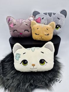 three stuffed cats sitting on top of each other in front of a white background with black fur