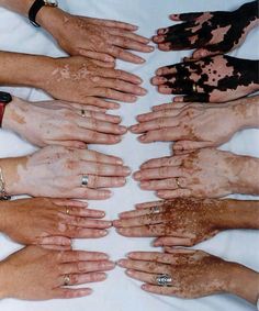 many hands are covered in brown and white mud