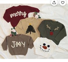 four sweaters with christmas designs on them sitting on a white sheet in the shape of a snowman