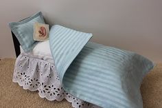 a bed with blue and white sheets on top of it next to a brown carpet