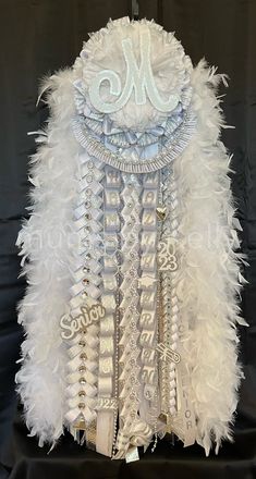 a white feather jacket with the letter m on it