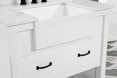 a white bathroom sink sitting under a mirror next to a wall mounted faucet