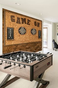 a room with a foosball table and darts on the wall