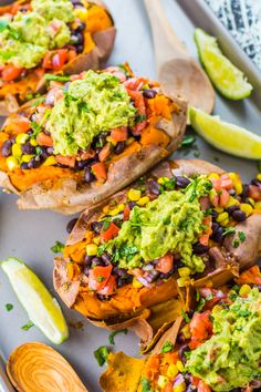 baked sweet potatoes topped with guacamole, black beans and avocado