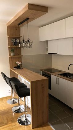 a kitchen with white cabinets and black chairs