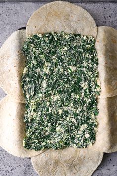 spinach and cheese on tortilla dough in the shape of a rectangle