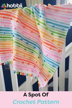 a colorful crocheted blanket sitting on top of a white chair