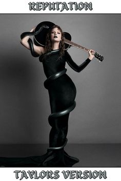 Taylor Swift wearing a long one-sleeved black body con dress holding a black guitar over her head with a long black snake wrapped around her body