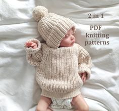 a baby wearing a knitted sweater and hat laying on top of a white blanket