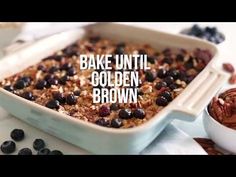 a baking dish filled with blueberries and nuts next to a bowl of walnuts