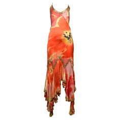 an orange and pink dress with flowers on the bottom, asymmetrically designed