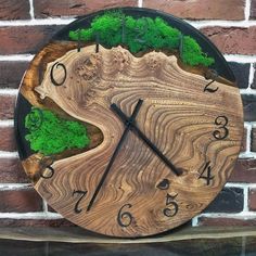 a wooden clock with moss growing on the sides and numbers in black, green and brown