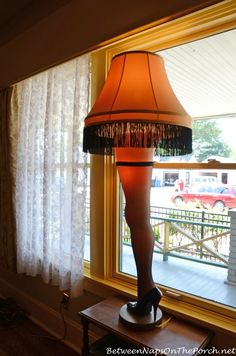 a lamp sitting on top of a table next to a window