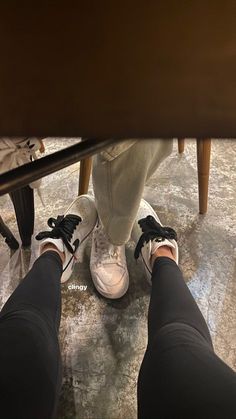 the legs and feet of a person standing under a table