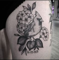 a bird sitting on top of a branch with flowers in it's back leg