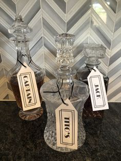 two decante bottles with labels on them sitting on a counter top next to each other