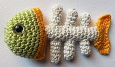 two crocheted fish made to look like they are holding each other's tails