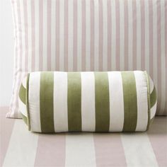 a green and white striped pillow sitting on top of a bed