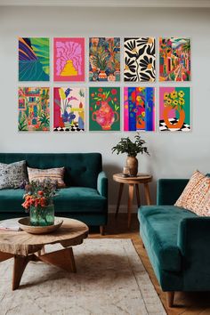 a living room filled with green couches and colorful paintings on the wall above them