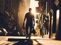 a man is walking down the street with his luggage