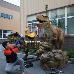 a young boy is playing with an inflatable dinosaur