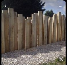 a wooden fence with gravel in front of it