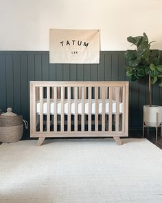 a baby crib sitting in front of a wall with a sign that says tatum like