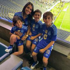 a group of young people sitting next to each other at a soccer game