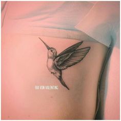 a woman's stomach with a hummingbird tattoo on it, and the words ha vin valentine written in white ink