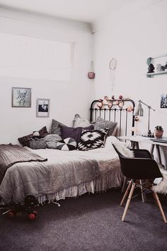 a bed sitting next to a desk in a room with pictures on the wall above it