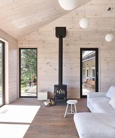 a living room with wood paneling and a fire place in the middle of it