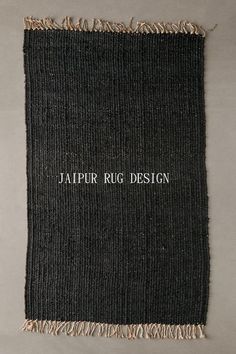 a black and white rug with fringes on the bottom is laying on a gray surface