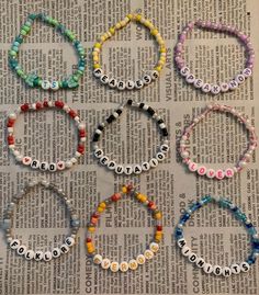 six bracelets made out of beads on top of a newspaper