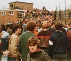 a crowd of people standing around each other