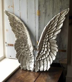 an angel statue sitting in front of a window with the words, may the angels rest their wings beside your door tonight